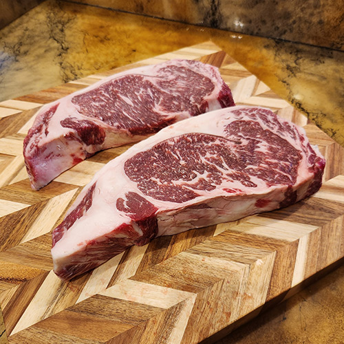 Fresh cut steaks on wooden cutting board